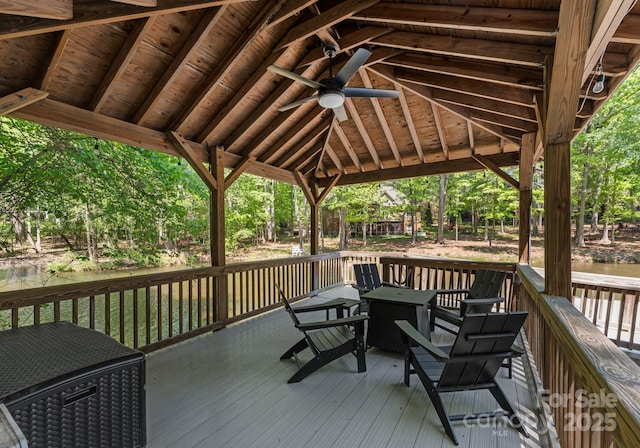 wooden deck featuring a water view and ceiling fan