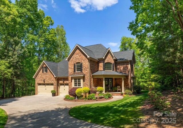 4273 Stormy Pointe Ct, Denver, NC 28037 - view of front of home featuring concrete driveway, brick siding, a front lawn, roof with shingles, and a porch