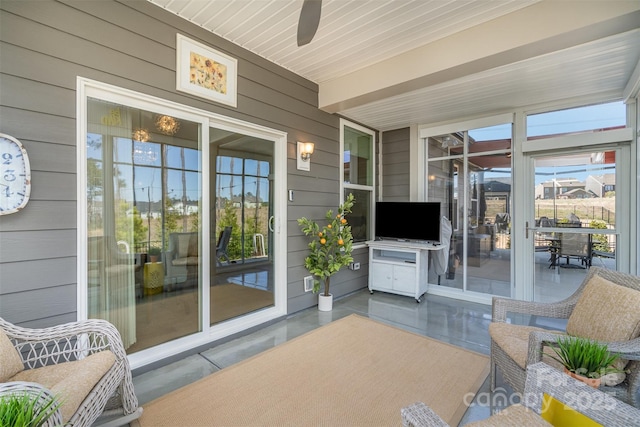 sunroom / solarium with a healthy amount of sunlight and ceiling fan