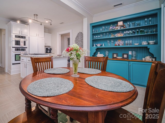 dining space featuring ornamental molding and visible vents