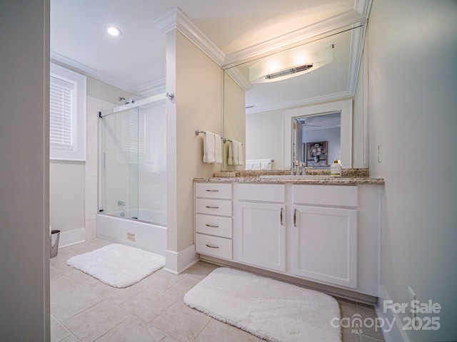 bathroom with baseboards, ornamental molding, tile patterned floors, vanity, and enclosed tub / shower combo