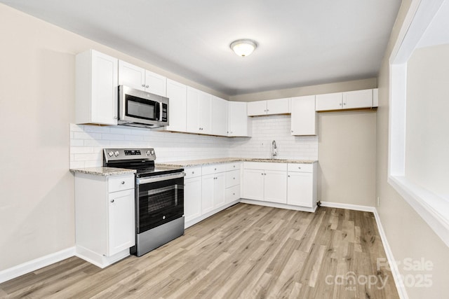2801 Alleghany St, Charlotte, NC 28208 - kitchen with white cabinetry, light wood-style flooring, backsplash, and stainless steel appliances