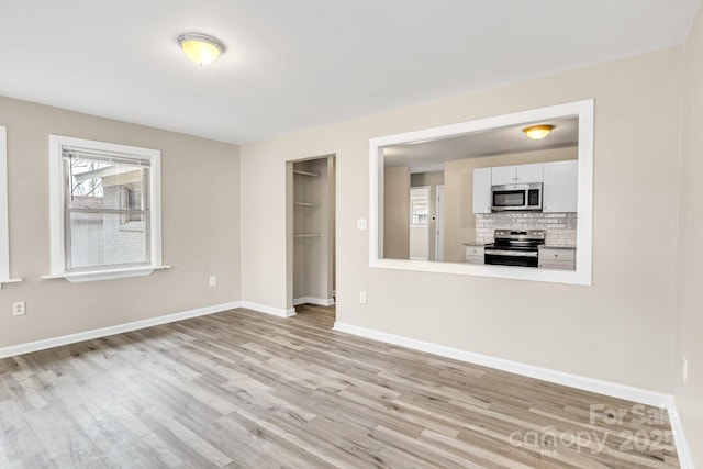2801 Alleghany St, Charlotte, NC 28208 - unfurnished living room with baseboards and light wood-style floors