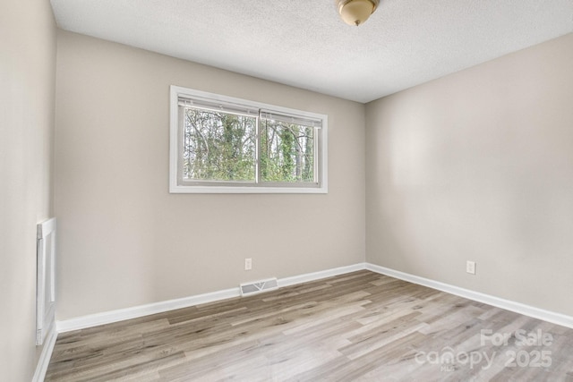2801 Alleghany St, Charlotte, NC 28208 - unfurnished room featuring a textured ceiling, baseboards, light wood finished floors, and visible vents