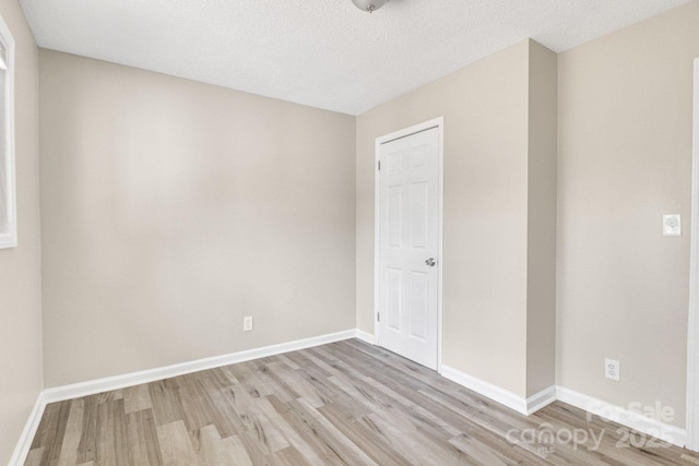 2801 Alleghany St, Charlotte, NC 28208 - empty room with light wood finished floors, baseboards, and a textured ceiling