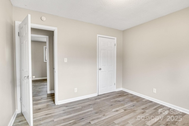 2801 Alleghany St, Charlotte, NC 28208 - unfurnished bedroom featuring a closet, baseboards, light wood finished floors, and a textured ceiling