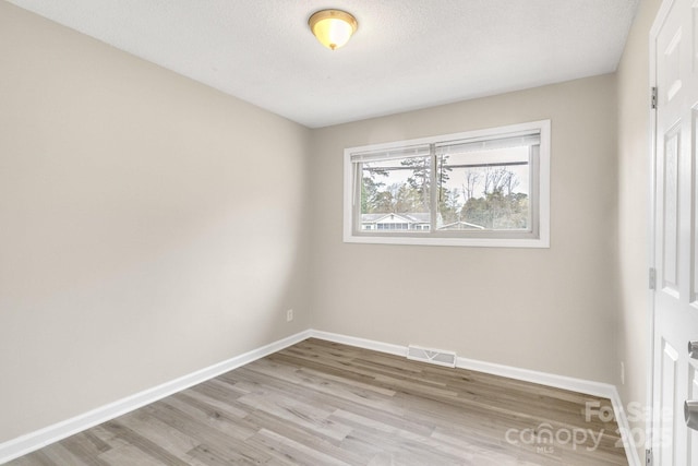 2801 Alleghany St, Charlotte, NC 28208 - empty room with wood finished floors, a textured ceiling, baseboards, and visible vents