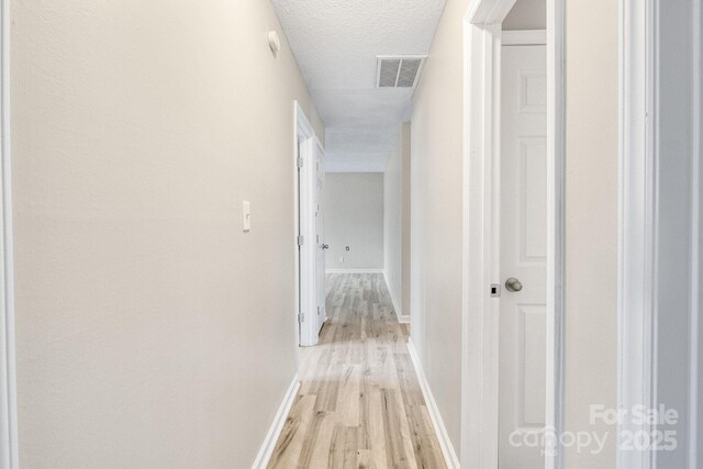 2801 Alleghany St, Charlotte, NC 28208 - hallway with baseboards, a textured ceiling, visible vents, and light wood finished floors