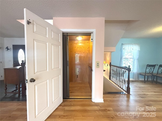 97 Hughes Dr, Maggie Valley, NC 28751 - entryway featuring wood-type flooring, a textured ceiling, and baseboards