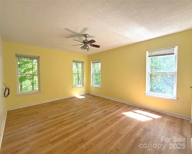 97 Hughes Dr, Maggie Valley, NC 28751 - unfurnished room with a textured ceiling, a ceiling fan, light wood-style flooring, and baseboards