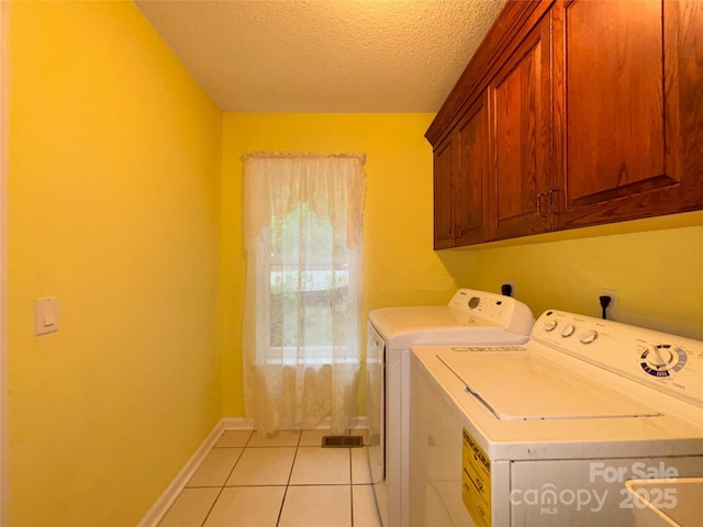 97 Hughes Dr, Maggie Valley, NC 28751 - laundry area featuring washer and clothes dryer, cabinet space, a textured ceiling, light tile patterned flooring, and baseboards