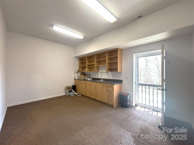 97 Hughes Dr, Maggie Valley, NC 28751 - kitchen with open shelves, a sink, dark countertops, a textured ceiling, and carpet flooring