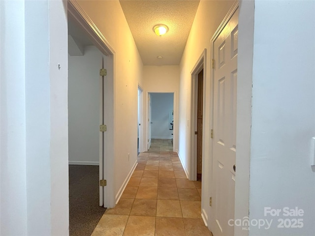 97 Hughes Dr, Maggie Valley, NC 28751 - corridor with a textured ceiling, light tile patterned flooring, and baseboards