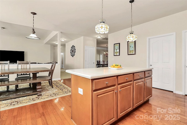 7925 Woodmere Dr, Harrisburg, NC 28075 - kitchen with light wood finished floors, decorative light fixtures, open floor plan, light countertops, and a center island