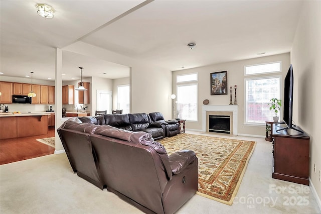 7925 Woodmere Dr, Harrisburg, NC 28075 - living room featuring light carpet, a glass covered fireplace, and plenty of natural light
