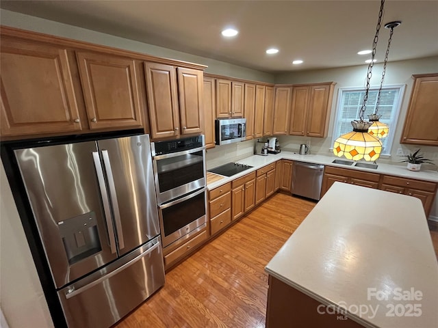 7925 Woodmere Dr, Harrisburg, NC 28075 - kitchen with appliances with stainless steel finishes, light wood-style floors, recessed lighting, hanging light fixtures, and light countertops