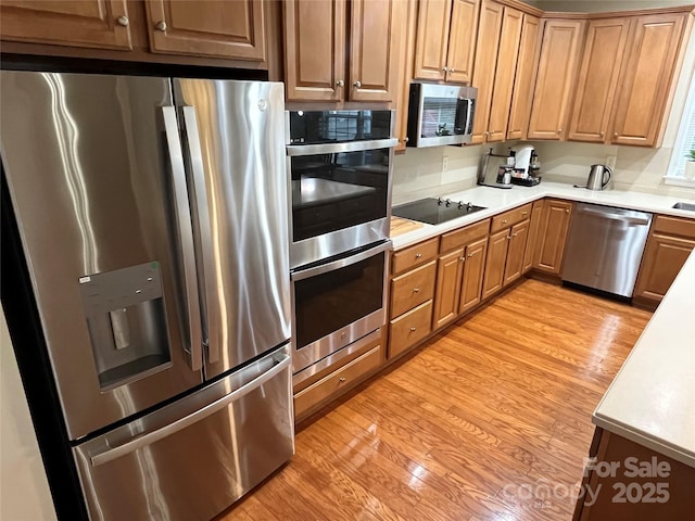 7925 Woodmere Dr, Harrisburg, NC 28075 - kitchen with appliances with stainless steel finishes, light countertops, and light wood-style flooring