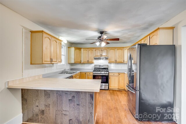 113 Hemphill Ave, Chester, SC 29706 - kitchen featuring light brown cabinets, under cabinet range hood, stainless steel appliances, and a peninsula