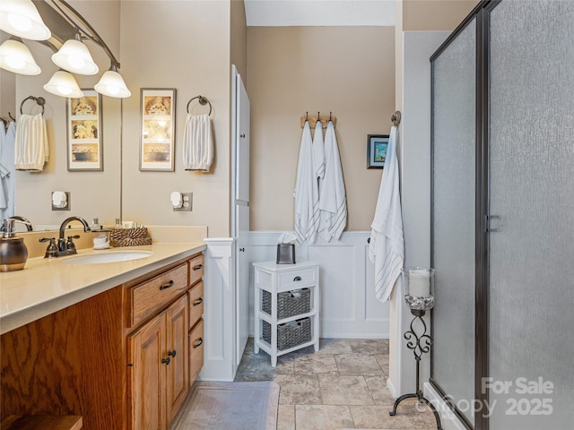 288 Hawks Point Dr, Zirconia, NC 28790 - full bath with a stall shower, vanity, wainscoting, a decorative wall, and stone finish floor