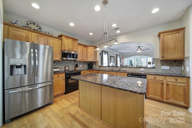 kitchen with stainless steel appliances, a ceiling fan, a kitchen island, a sink, and light wood-type flooring