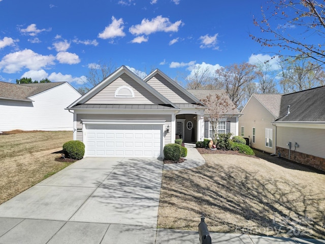 ranch-style house featuring metal roof, an attached garage, a standing seam roof, and driveway