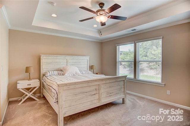 bedroom featuring crown molding, a tray ceiling, light colored carpet, baseboards, and visible vents