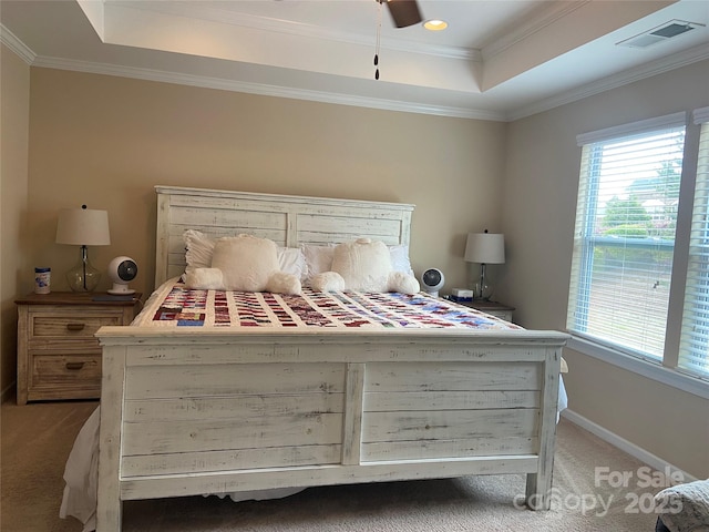 bedroom with light carpet, visible vents, a raised ceiling, and multiple windows