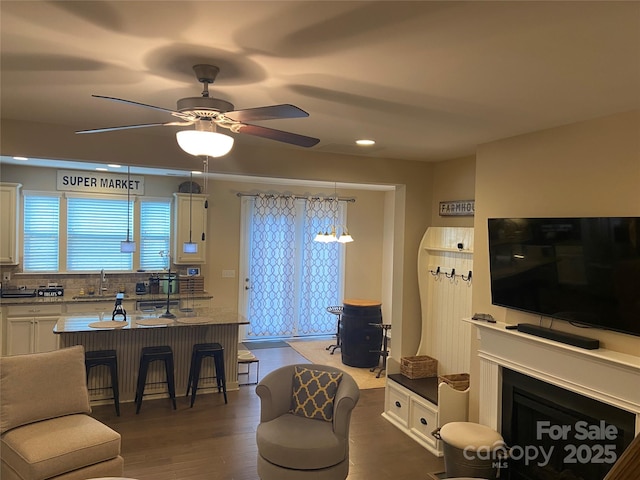 living area featuring a ceiling fan, recessed lighting, and dark wood-style flooring