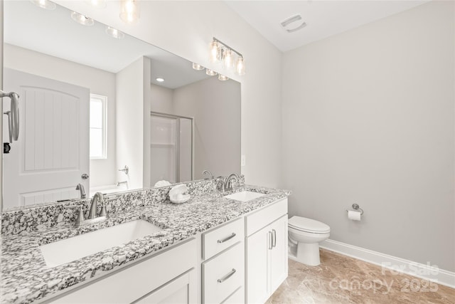 bathroom featuring a shower stall, toilet, double vanity, and baseboards