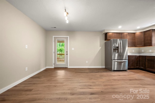 371 Amber Oaks Dr, Rutherfordton, NC 28139 - kitchen with stainless steel fridge, baseboards, light wood-style floors, dark brown cabinets, and light countertops