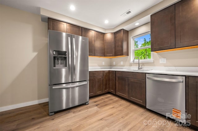 371 Amber Oaks Dr, Rutherfordton, NC 28139 - kitchen featuring appliances with stainless steel finishes, a sink, light wood finished floors, light countertops, and dark brown cabinets