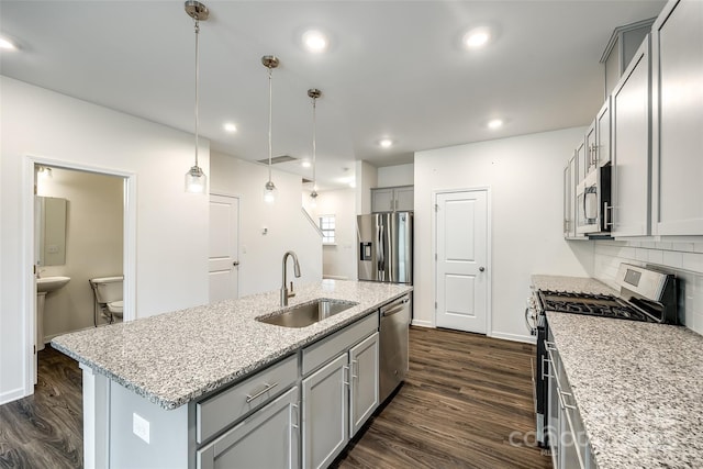 kitchen featuring a sink, stainless steel appliances, dark wood-style flooring, decorative backsplash, and gray cabinetry
