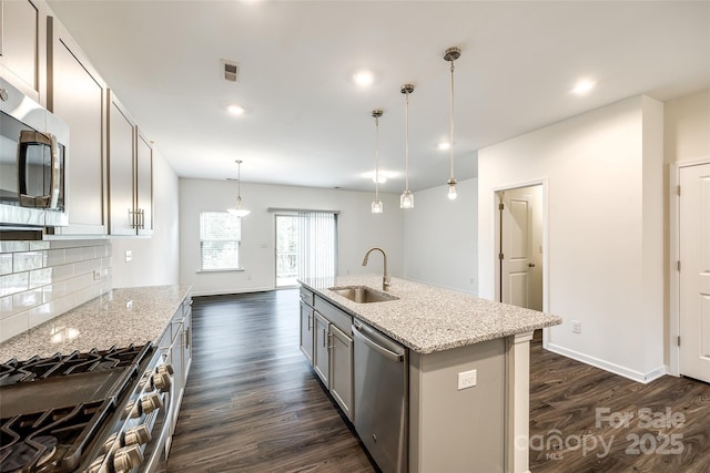 kitchen featuring a sink, stainless steel appliances, dark wood-type flooring, visible vents, and decorative backsplash