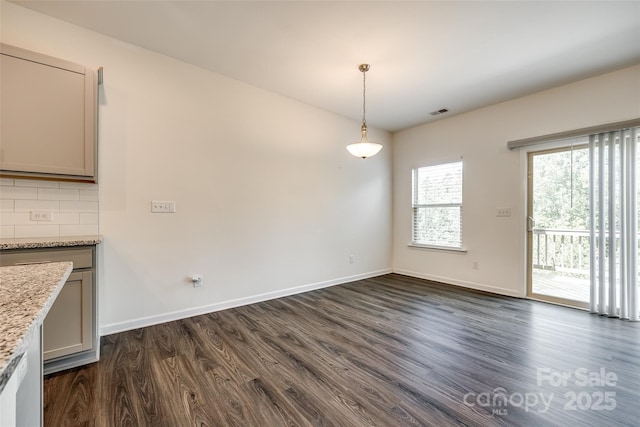 unfurnished dining area featuring visible vents, baseboards, and dark wood-style floors