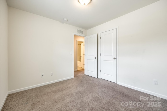 unfurnished bedroom featuring carpet flooring, visible vents, and baseboards