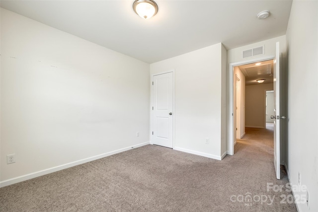unfurnished bedroom featuring baseboards, attic access, visible vents, and carpet floors