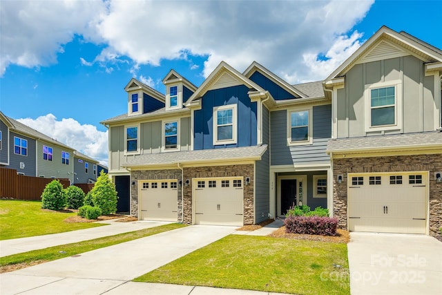view of front of home with concrete driveway, an attached garage, stone siding, and board and batten siding