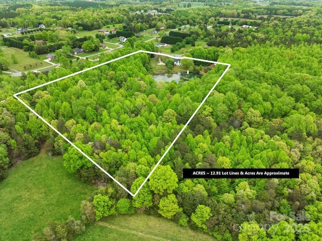 birds eye view of property featuring a wooded view