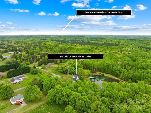 birds eye view of property featuring a wooded view