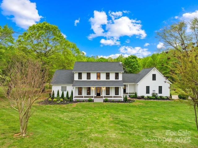 view of front of house with roof with shingles, a front yard, and covered porch