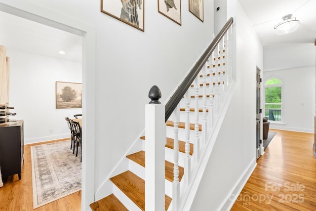 stairs with wood finished floors and baseboards