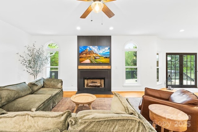 living area featuring ceiling fan, a large fireplace, wood finished floors, and recessed lighting
