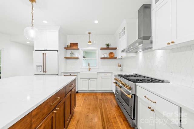 kitchen with wall chimney range hood, open shelves, a sink, white appliances, and light countertops
