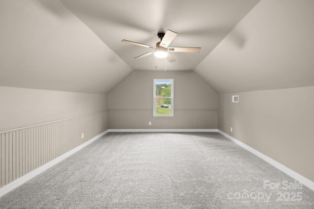 additional living space featuring vaulted ceiling, baseboards, visible vents, carpet, and a ceiling fan