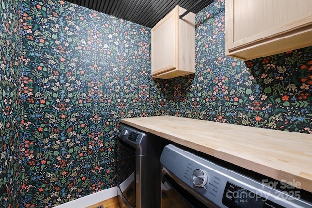 bathroom with separate washer and dryer and wallpapered walls