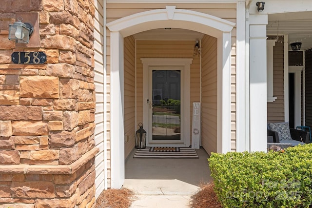 entrance to property featuring a porch and stone siding
