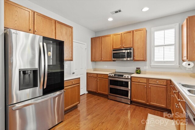 kitchen with recessed lighting, stainless steel appliances, light countertops, wood finished floors, and visible vents