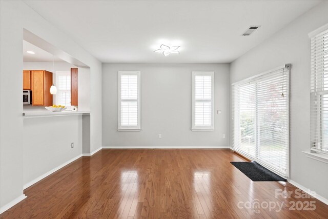 interior space with baseboards, wood finished floors, visible vents, and recessed lighting