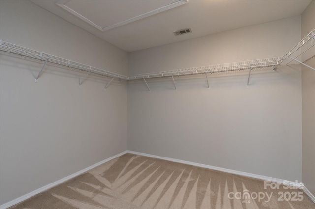 walk in closet with visible vents and light colored carpet