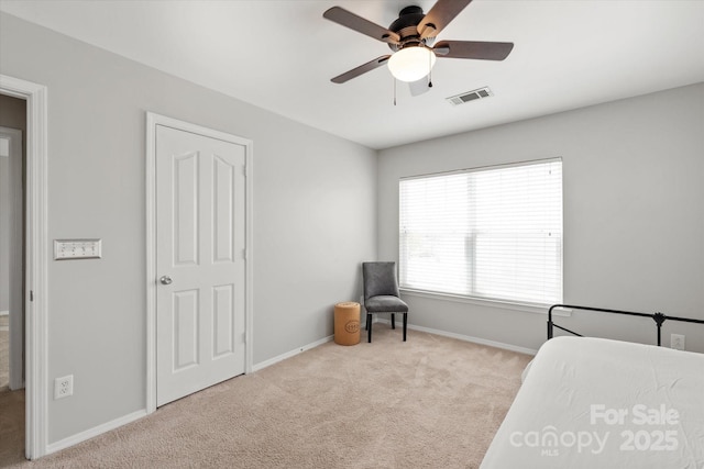 carpeted bedroom featuring visible vents, a ceiling fan, and baseboards